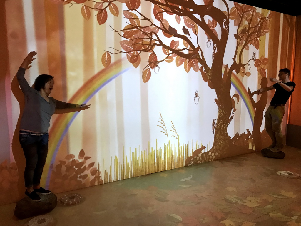 Miaomiao and a friend with a projection of a rainbow at the `Beleef Ontdek Samen: BOS` exhibition at the second floor of the Natuurmuseum Brabant