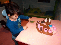 Max playing with a Dinosaur toy in the home of Kikker at the `Kikker is hier!` exhibition at the second floor of the Natuurmuseum Brabant