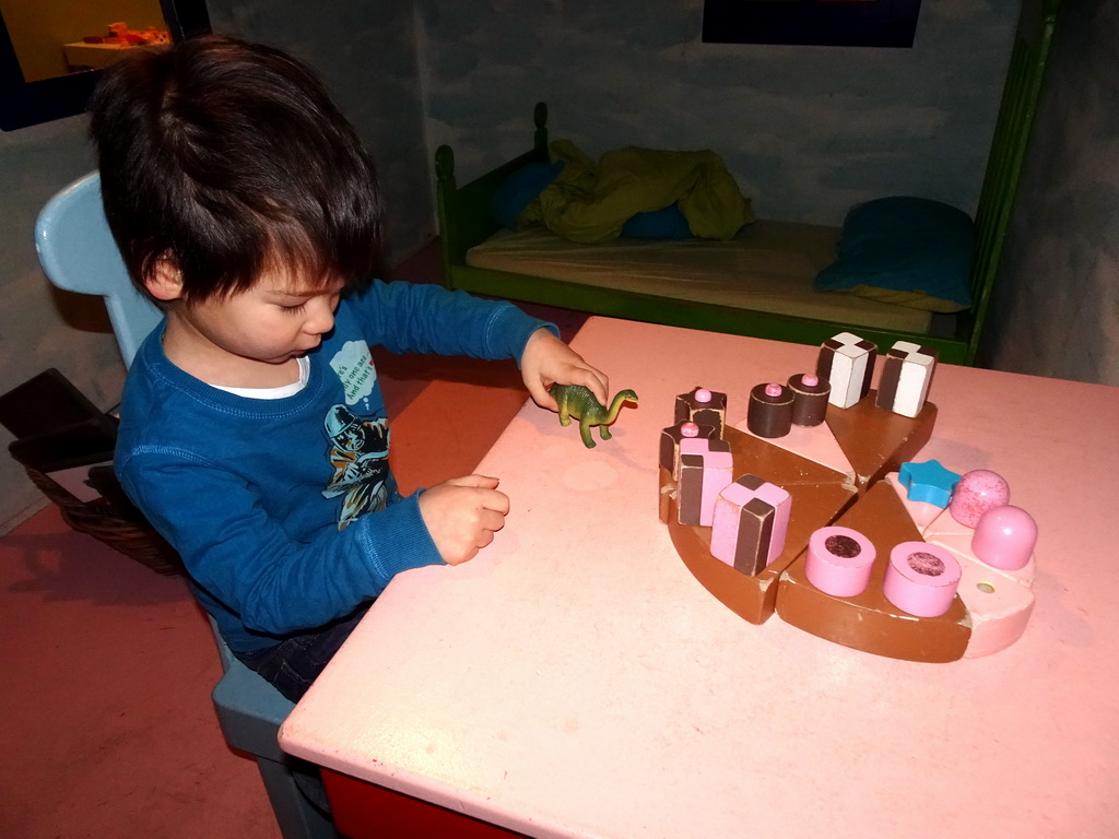 Max playing with a Dinosaur toy in the home of Kikker at the `Kikker is hier!` exhibition at the second floor of the Natuurmuseum Brabant