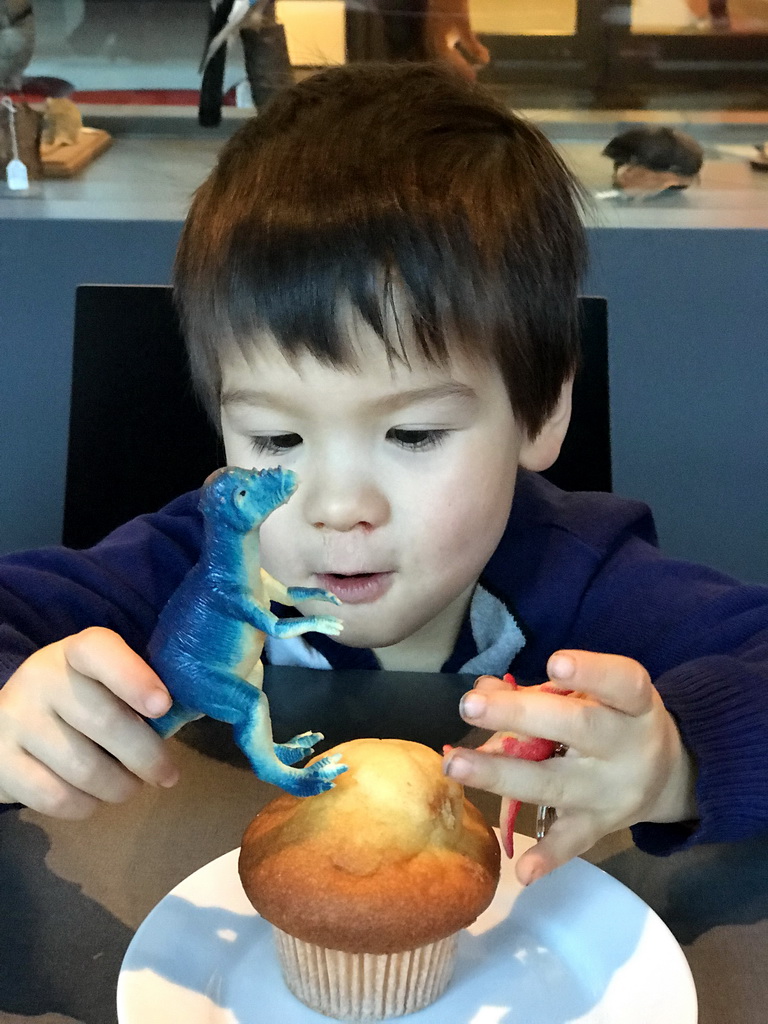 Max with dinosaur toys and a muffin at the Museumcafé at the ground floor of the Natuurmuseum Brabant