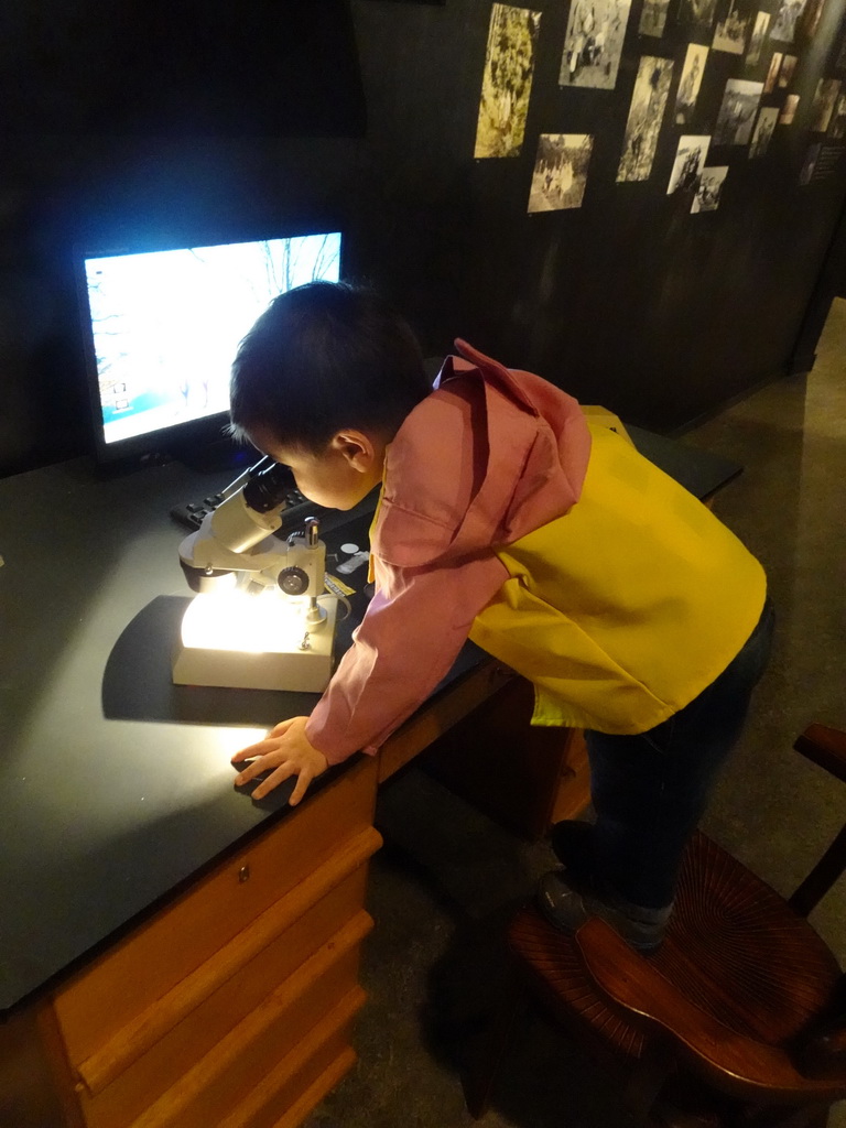 Max looking through a microscope at the `Jouw Brabant, mijn Brabant - een landschap vol herinneringen` exhibition at the first floor of the Natuurmuseum Brabant