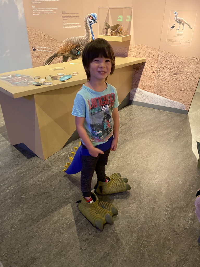 Max with dinosaur tail and feet at the `Vreemde vogels, die dino`s` exhibition at the second floor of the Natuurmuseum Brabant