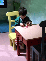 Max at the table in the home of Kikker at the `Kikker is hier!` exhibition at the second floor of the Natuurmuseum Brabant