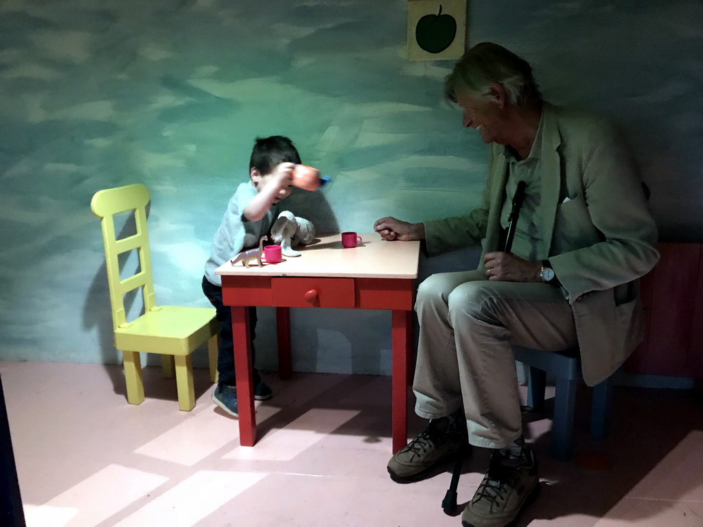 Max and his grandfather at the table in the home of Kikker at the `Kikker is hier!` exhibition at the second floor of the Natuurmuseum Brabant