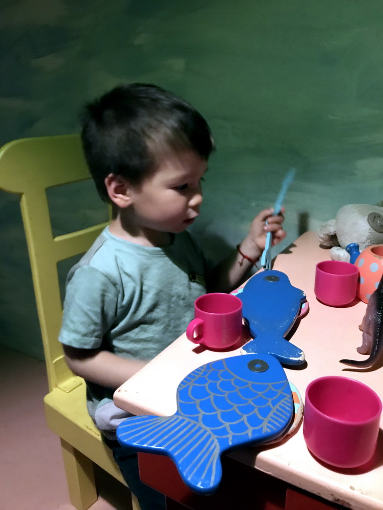 Max at the table in the home of Kikker at the `Kikker is hier!` exhibition at the second floor of the Natuurmuseum Brabant