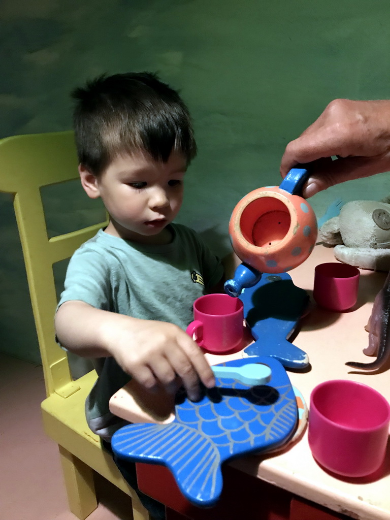 Max at the table in the home of Kikker at the `Kikker is hier!` exhibition at the second floor of the Natuurmuseum Brabant