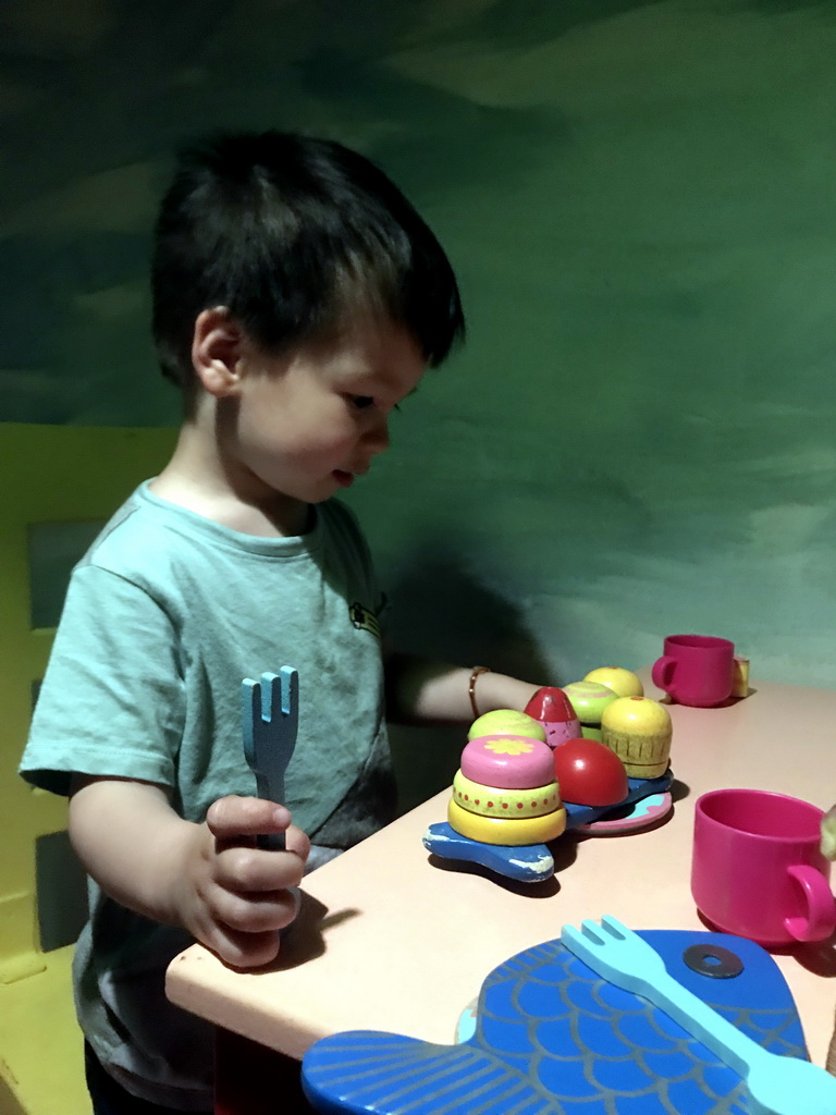 Max at the table in the home of Kikker at the `Kikker is hier!` exhibition at the second floor of the Natuurmuseum Brabant