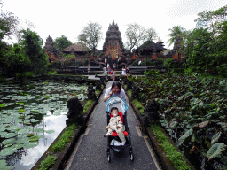 Miaomiao and Max at the pond with lotus plants and the front of the Pura Taman Saraswati temple