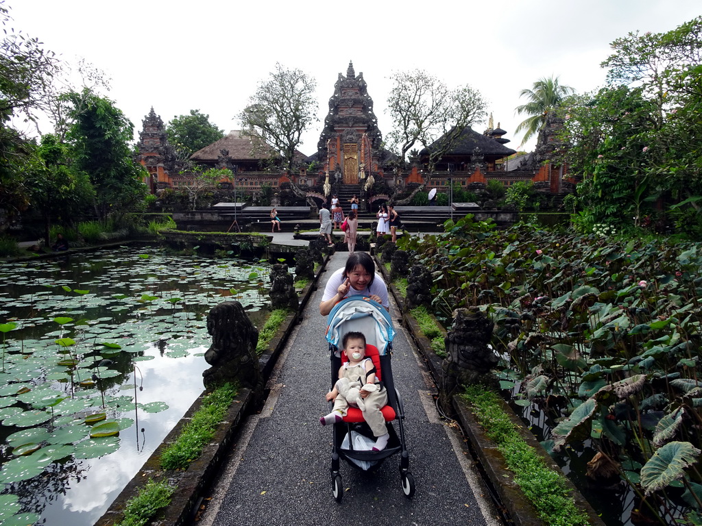 Miaomiao and Max at the pond with lotus plants and the front of the Pura Taman Saraswati temple