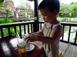 Max at the terrace of Café Lotus, with a view on the pond with lotus plants and the front of the Pura Taman Saraswati temple