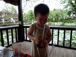 Max drinking ice tea at the terrace of Café Lotus, with a view on the pond with lotus plants and the front of the Pura Taman Saraswati temple