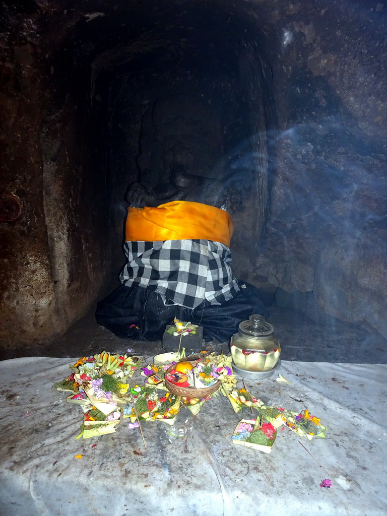 Ganesha statue with offerings in the `Elephant Cave` at the Goa Gajah temple