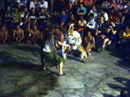 Haruman dancing with a tourist during Act 4 of the Kecak and Fire Dance at the Amphitheatre of the Pura Luhur Uluwatu temple, by night