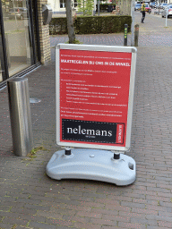 Sign about the COVID-19 rules in front of the Nelemans Mode shop at the Dorpsstraat street