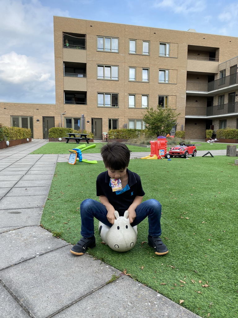 Max with a Pokémon card at the central square of the apartment block at the Aidadreef street