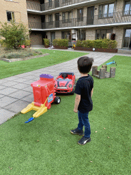 Max with a toy car at the central square of the apartment block at the Aidadreef street