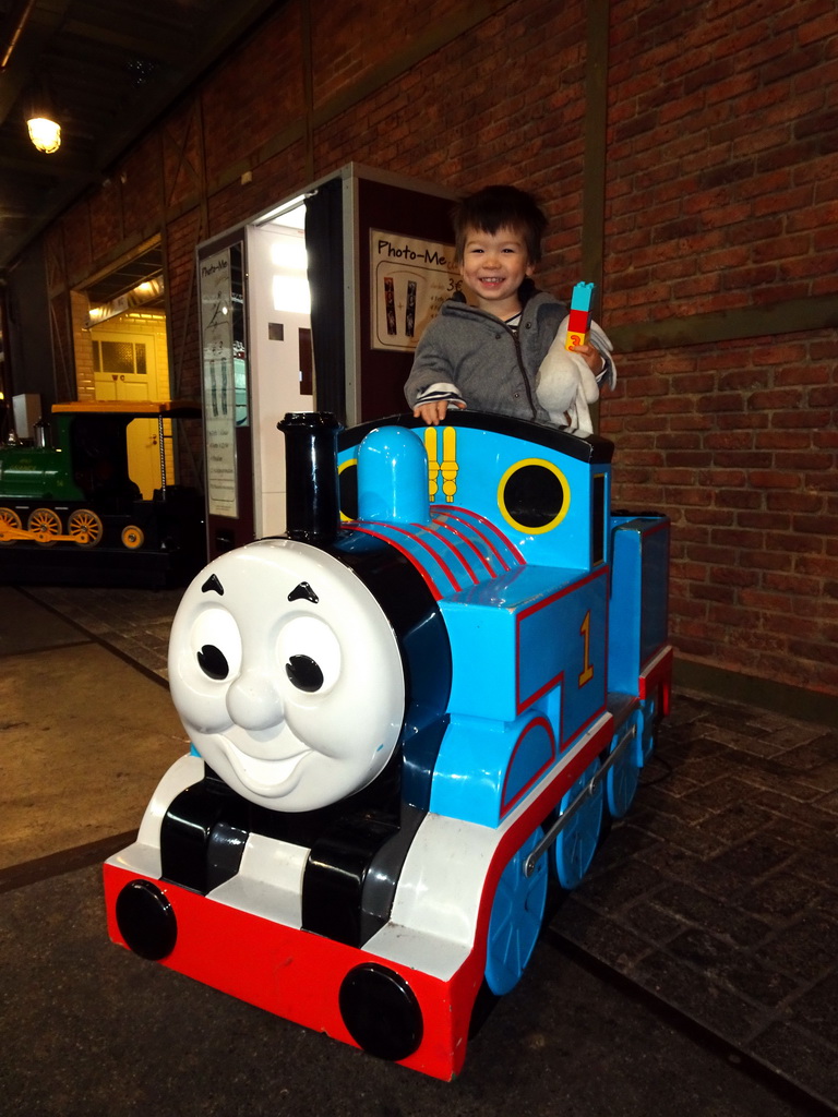 Max on the Thomas the Tank Engine rocking train in front of the De Remise restaurant at the Werkplaats hall at the Spoorwegmuseum