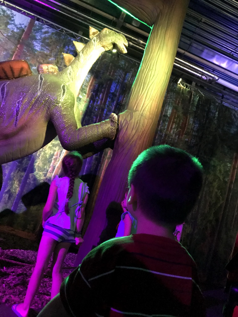 Max with a Wuerhosaurus statue leaning on a tree at the World of Dinos exhibition at the Jaarbeurs building