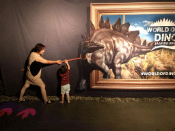 Miaomiao and Max pretending to catch a Stegosaurus at the World of Dinos exhibition at the Jaarbeurs building
