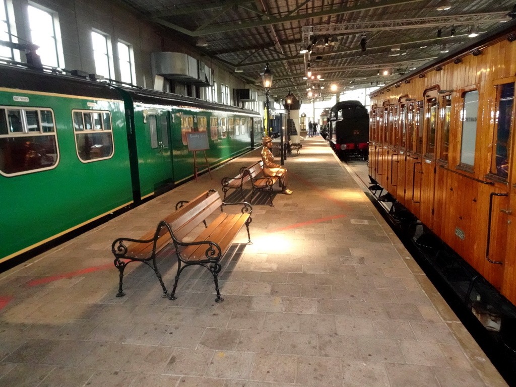 Old trains and a bronze statue at the `Treinen door de Tijd` exhibition at the Werkplaats hall of the Spoorwegmuseum