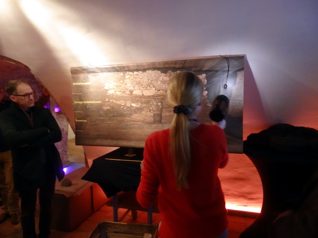 Tour guide with a flashlight and a photograph of the different layers in the earth at the Domplein area, at the introduction room of the DomUnder exhibition building