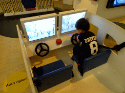 Max driving a car at the Traffic Room at the upper floor of the Nijntje Winter Museum