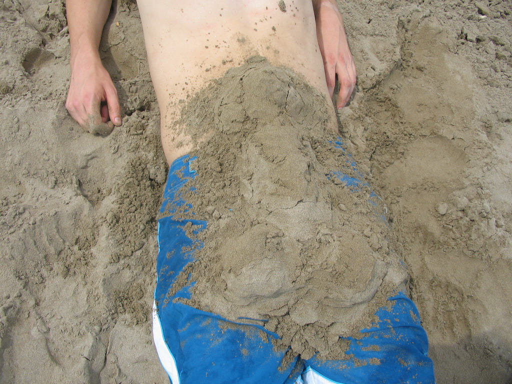 Tim buried under the sand at the beach at the east side of Valencia