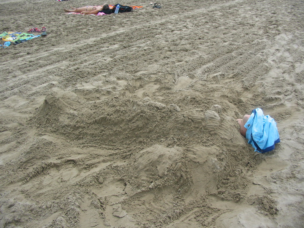 Tim buried under the sand at the beach at the east side of Valencia