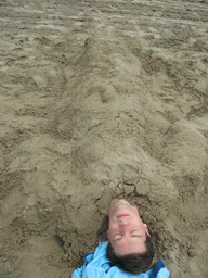 Tim buried under the sand at the beach at the east side of Valencia