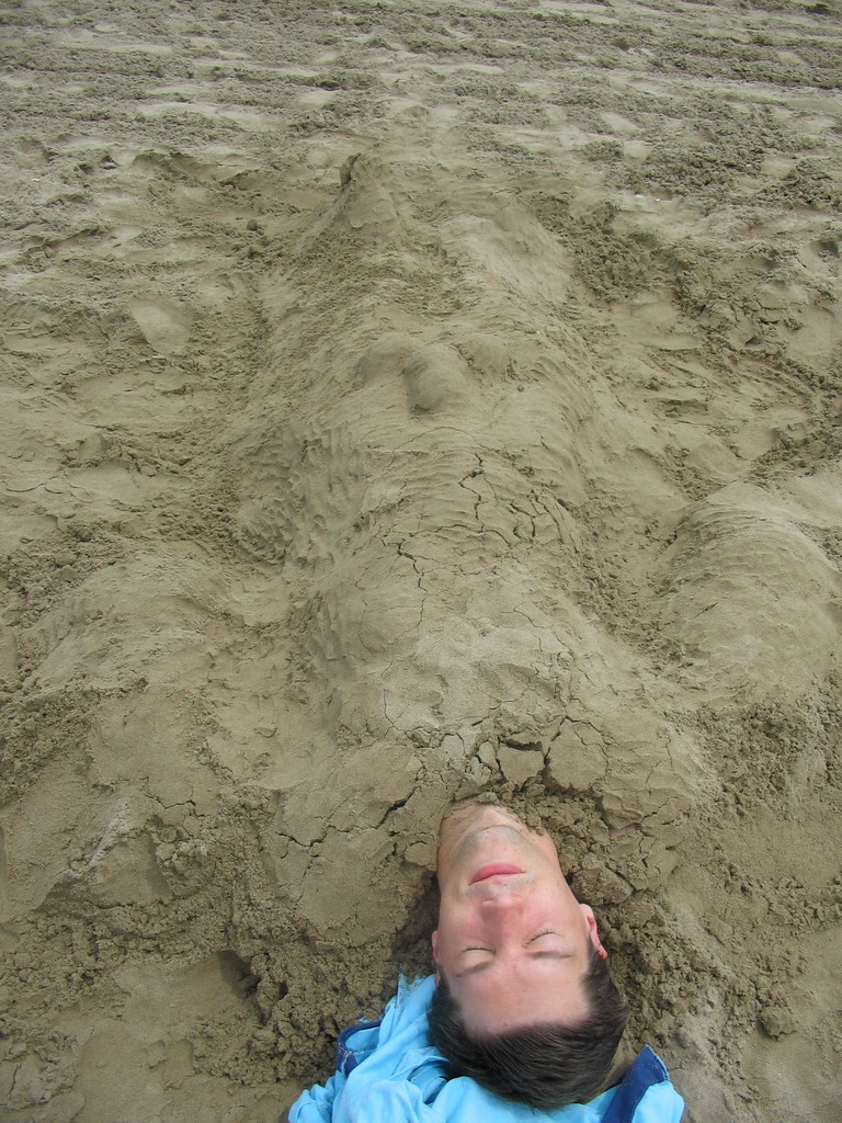 Tim buried under the sand at the beach at the east side of Valencia