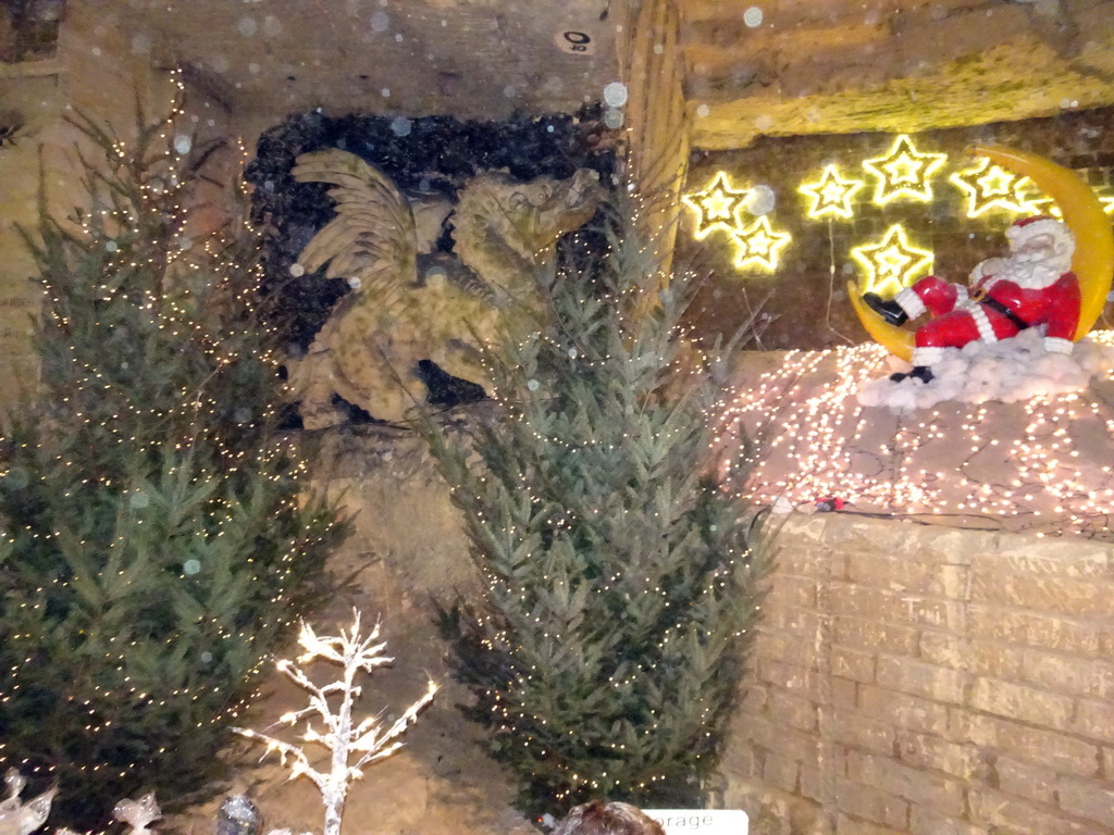 Christmas trees and decorations and a relief of a dragon at the christmas market at the Municipal Cave