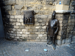 Statue and relief at the west side of the Grendelpoort gate at the Muntstraat street