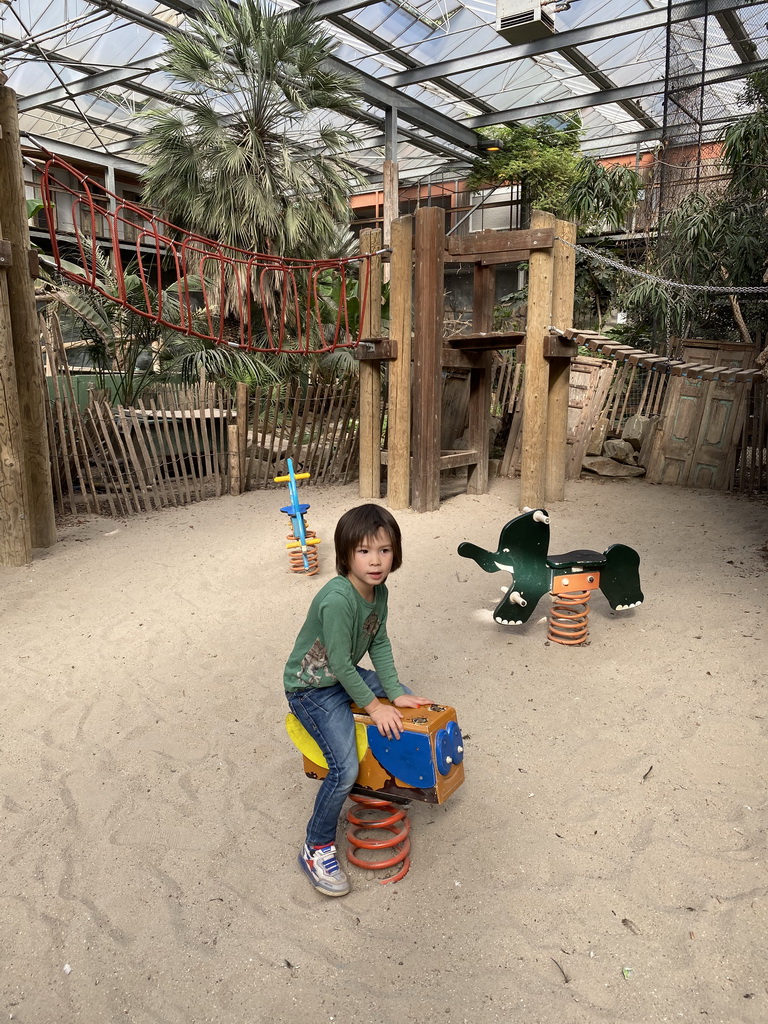 Max on a rocking horse at the playground in the Bamboo Jungle hall at Zoo Veldhoven