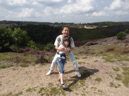 Miaomiao and Max on the top of the Posbank hill, with a view on the sand, trees and purple heather on the northwest side