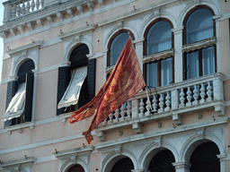 Venetian flag in front of a house at the Canal Grande, viewed from the Canal Grande ferry