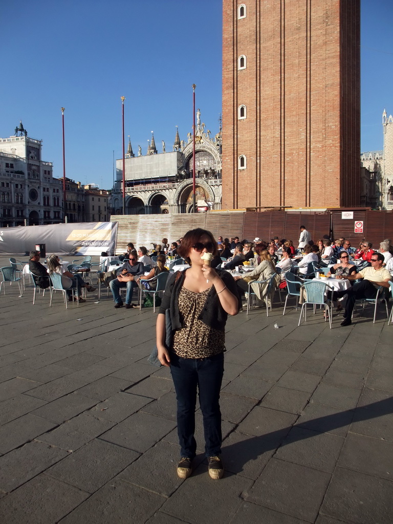 Miaomiao with an icecream on the Piazza San Marco square with the front of the Basilica di San Marco church, its Campanile Tower and the Clock Tower