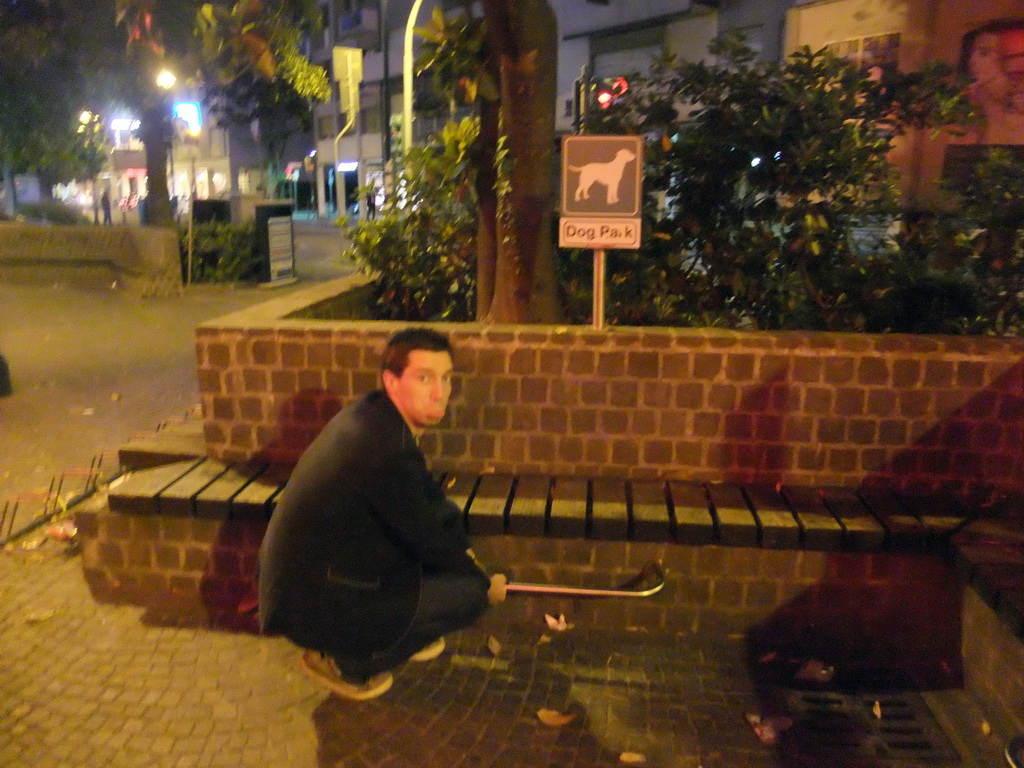 Tim with `Dog Park` sign at a square in Mestre, by night