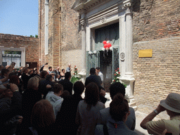People throwing rice at a married couple in front of the Chiesa di San Pietro Martire church at the Murano islands