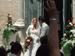 People throwing rice at a married couple in front of the Chiesa di San Pietro Martire church at the Murano islands