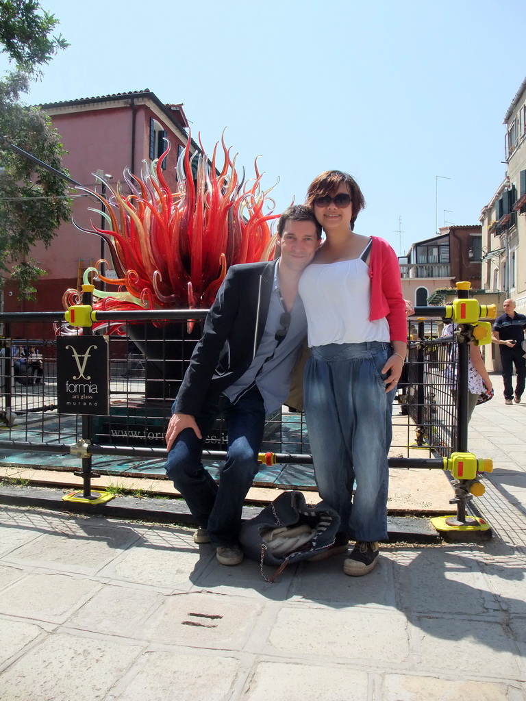 Tim and Miaomiao with a glass piece of art at the Calle Bressagio street at the Murano islands