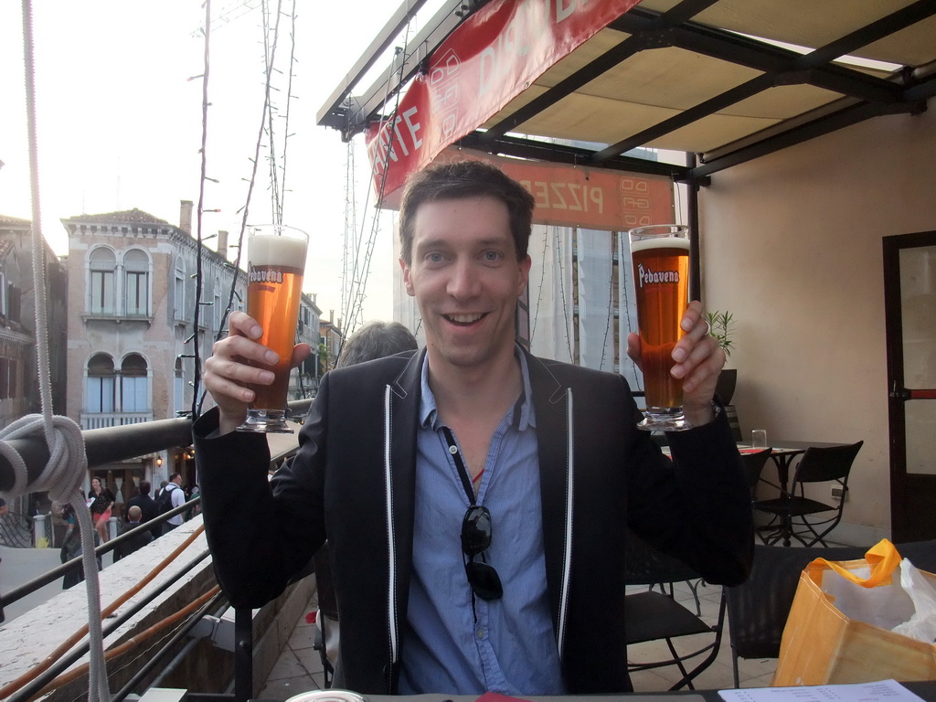 Tim with two Pedavena beers at the roof terrace of a restaurant at the Strada Nuova street