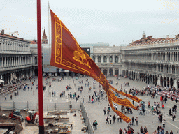 Venetian flag and the Piazza San Marco square with the Procuratie Nuove building, the Napoleonic Wing of the Procuraties building and the Procuratie Vecchie building, viewed from the loggia of the Basilica di San Marco church