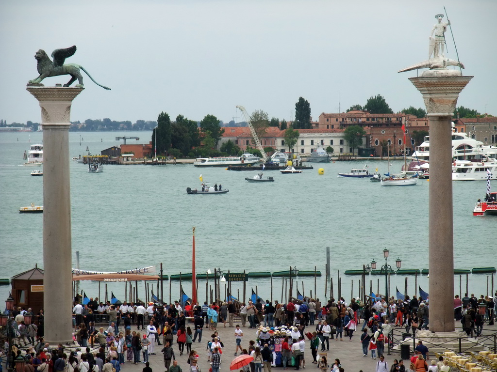 The columns with the sculptures `Lion of Venice` and `Saint Theodore` on top at the Piazzetta San Marco square, the Giudecca island and the Bacino di San Marco basin, viewed from the loggia of the Basilica di San Marco church