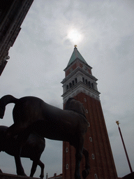 The replica Horses of Saint Mark statues at the loggia of the Basilica di San Marco church, with a view on the Campanile Tower
