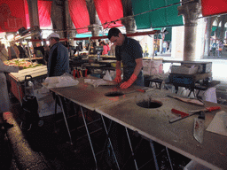 Merchant cutting fish at the fish market at the Mercato del Pesce al Minuto building