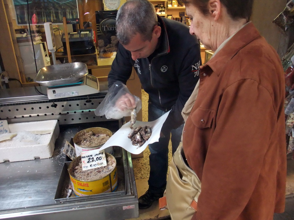 Merchant selling small fish at the fish market at the Calle Beccarie Cannaregio street