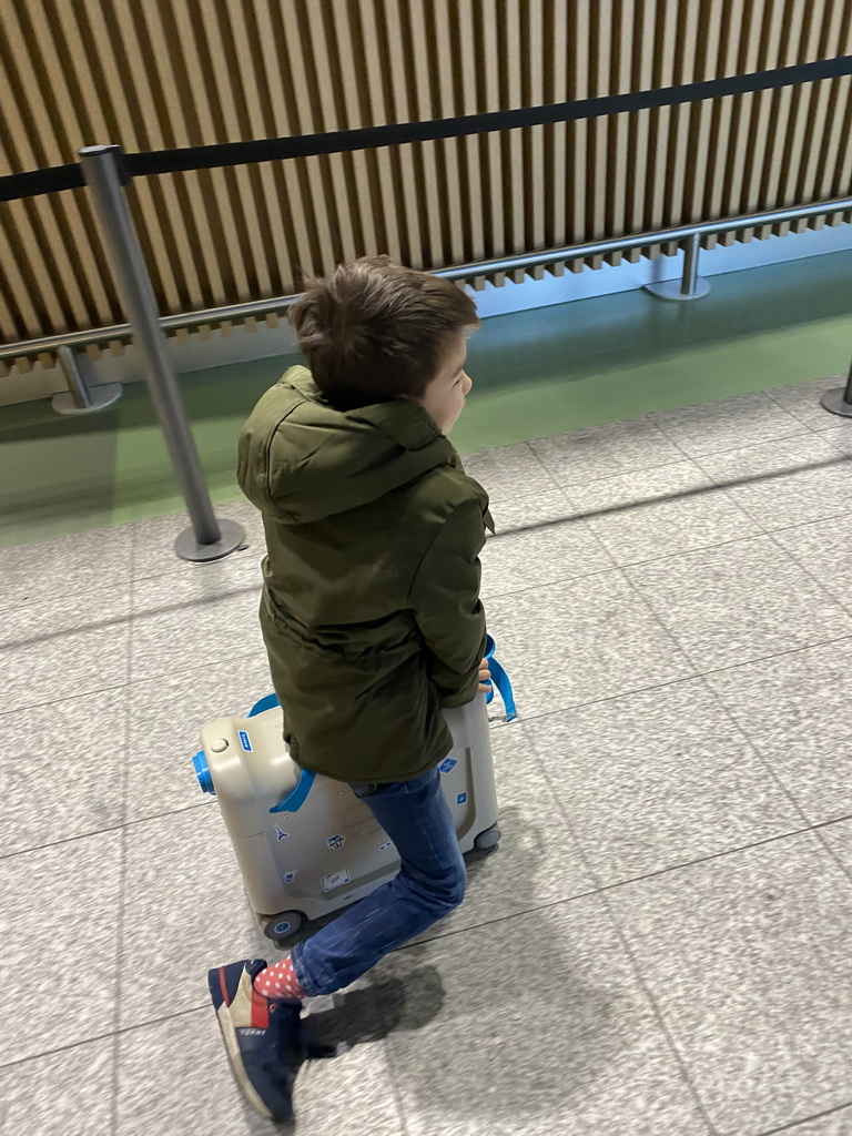 Max on his suitcase at the Departures Hall of Eindhoven Airport