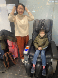 Miaomiao and Max in a massage chair at the Arrivals Hall of Vienna International Airport
