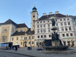 Austriabrunnen fountain and the front of the Benediktushaus im Schottenstift hotel at the Freyung square