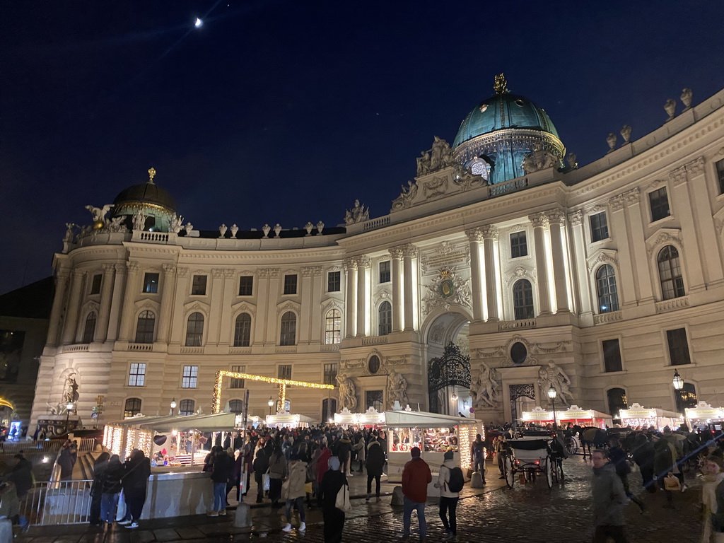 Front of the Hofburg palace and christmas stalls at the Michaelerplatz square, by night